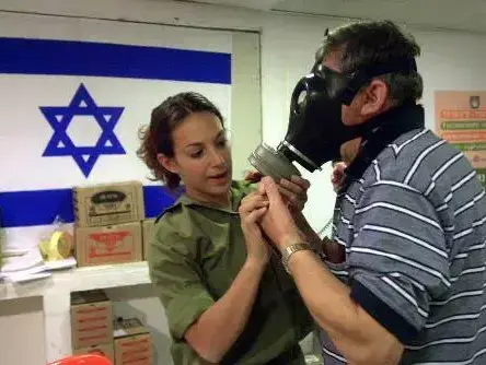 חיילת מסבירה לאזרח איך לשים מסיכת אב"כ, 1991 (AP , אליזבת דלזיאל) חיילת מסבירה לאזרח איך לשים מסיכת אב"כ, 1991 (AP , אליזבת דלזיאל)