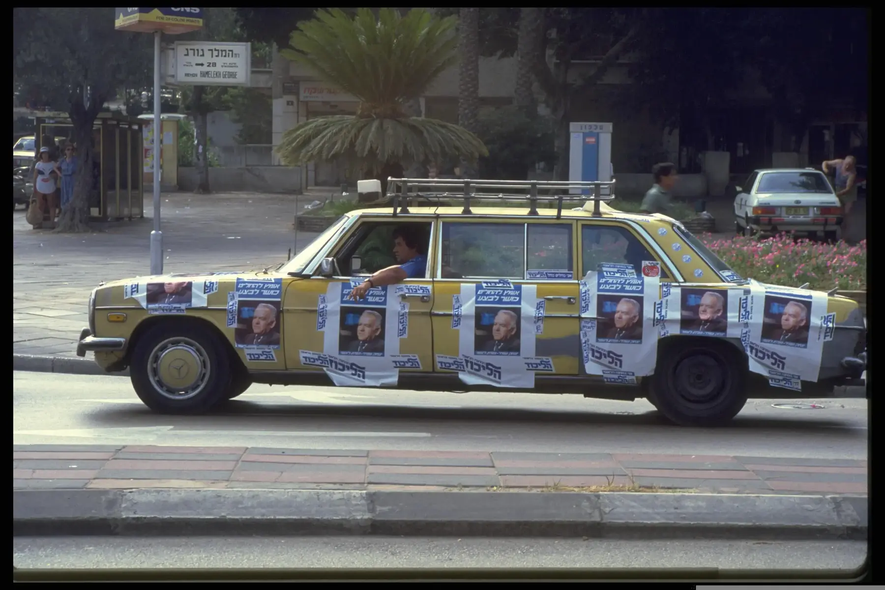 מונית עם כרזות בחירות של תנועת הליכוד בתל אביבי, ביום הבחירות לכנסת 23 ביולי 1984 (לשכת העיתונות הממשלתית , נתי הרניק) מונית עם כרזות בחירות של תנועת הליכוד בתל אביבי, ביום הבחירות לכנסת 23 ביולי 1984 (לשכת העיתונות הממשלתית , נתי הרניק)