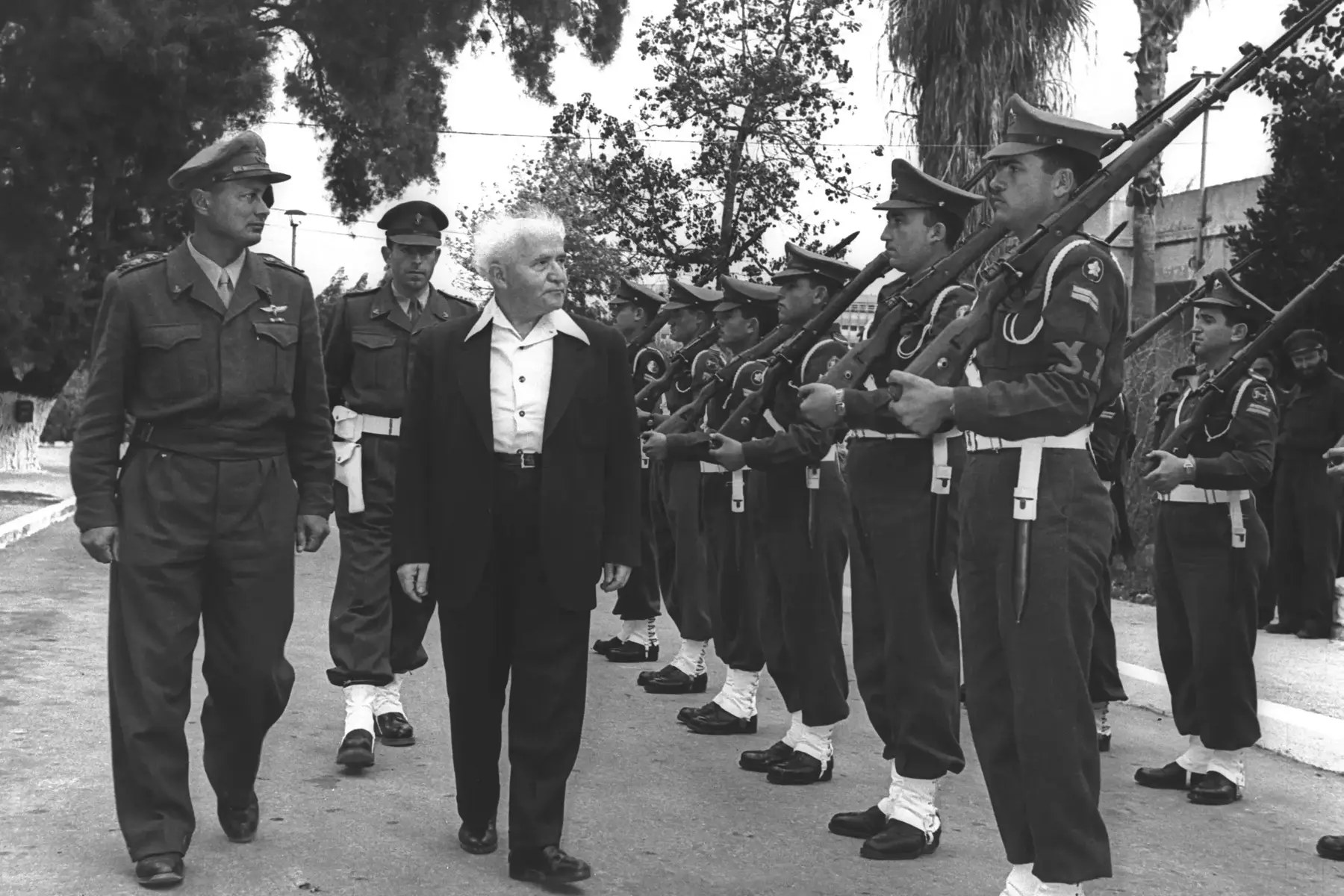 ראש הממלשה דוד בן גוריון מלווה ע"י הרמטכ"ל משה דיין סוקר משמר כבוד, מחוץ למשרדו בקרייה בתל אביב, פברואר 1955 (לשכת העיתונות הממשלתית , הנס פין) ראש הממלשה דוד בן גוריון מלווה ע"י הרמטכ"ל משה דיין סוקר משמר כבוד, מחוץ למשרדו בקרייה בתל אביב, פברואר 1955 (לשכת העיתונות הממשלתית , הנס פין)