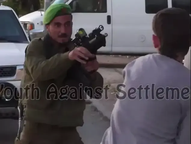 חייל נח"ל שתועד דורך נשק ומכוון אותו לעבר נער פלסטיני בחברון, אפריל 2014 (צילום מסך)