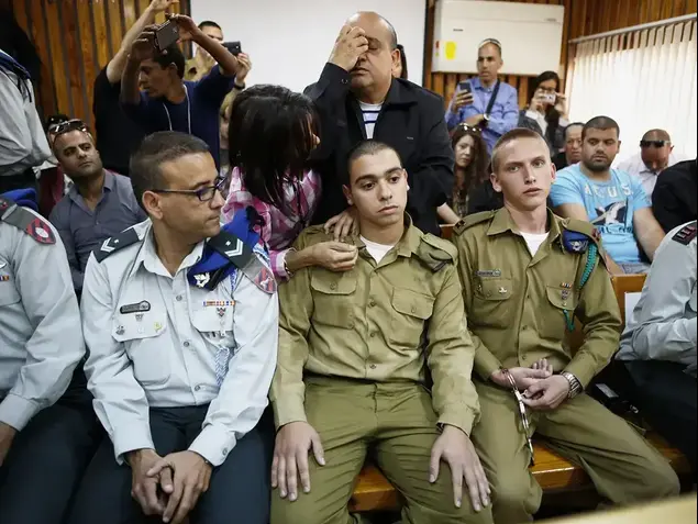 החייל אלאור אזריה, הנאשם בהריגת מחבל מנוטרל בחברון, והוריו (מאחוריו). (יח"צ , אמיר כהן / רויטרס)