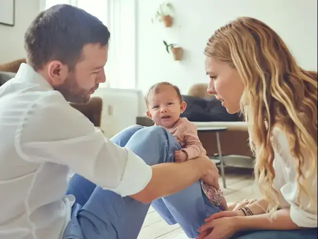 הורים צעירים מביטים בדאגה על התינוק שלהם (ShutterStock)