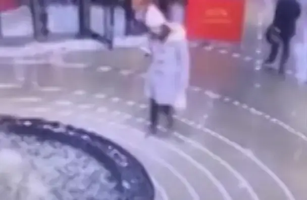אישה נופלת למזרקה עם הראש בנייד (צילום מסך)