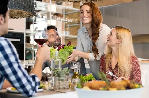 אישה מארחת חברים לארוחת ערב (ShutterStock)
