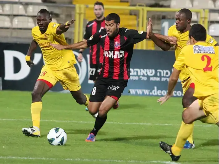 הישאם כיוואן שחקן הפועל חיפה (אמצע) מול ג'ואון אושאניווה שחקן מ.ס. אשדוד (אדריאן הרבשטיין) הישאם כיוואן שחקן הפועל חיפה (אמצע) מול ג'ואון אושאניווה שחקן מ.ס. אשדוד (אדריאן הרבשטיין)