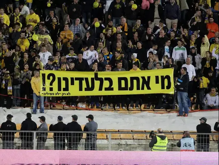 אוהדי בית"ר ירושלים עם שלט "מי אתם בלעדינו?" (אדריאן הרבשטיין) אוהדי בית"ר ירושלים עם שלט "מי אתם בלעדינו?" (אדריאן הרבשטיין)
