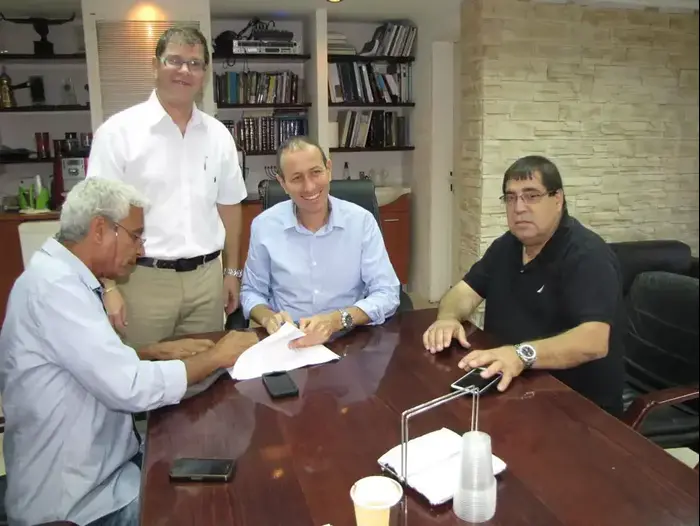 מעמד החתימה של הפועל עכו: עזרא גורש חותם (משמאל), ראש העיר שמעון לנקרי (במרכז), יו"ר הקבוצה יהודה ברשישת (יח"צ , עיריית עכו)