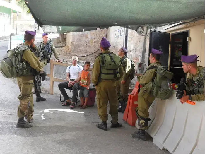 חיילי צה"ל מעכבים ילד פלסטיני בן 5 ואביו בחברון, 9 ביולי 2013 (יח"צ , ISM) חיילי צה"ל מעכבים ילד פלסטיני בן 5 ואביו בחברון, 9 ביולי 2013 (יח"צ , ISM)