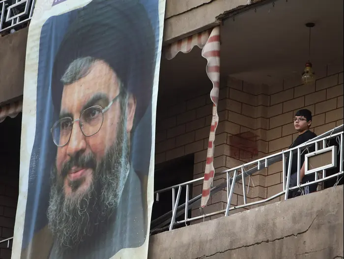 כרזה של חסן נסראללה מכסה נזקים על בניין שניזוק בפיגוע התאבדות ברובע דאחייה. ביירות, 22 בינואר 2014 (AP) כרזה של חסן נסראללה מכסה נזקים על בניין שניזוק בפיגוע התאבדות ברובע דאחייה. ביירות, 22 בינואר 2014 (AP)