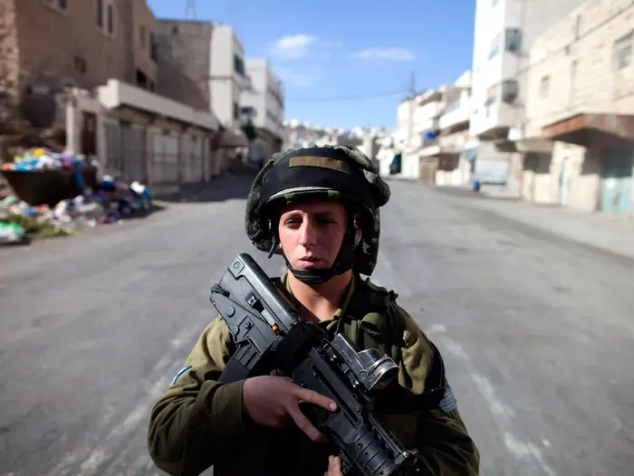 שוטר מג"ב משוחח עם מתנחל בכניסה אל מערת המכפלה. חברון, 2010 (AP)