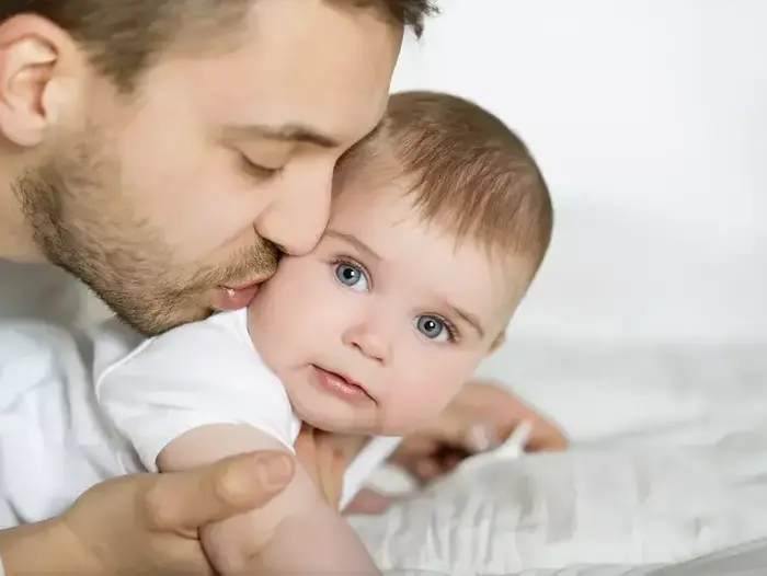 אב מנשק תינוק (ShutterStock) אב מנשק תינוק (ShutterStock)