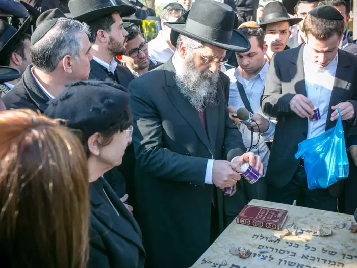 בניו ובתו של עובדיה יוסף בקברו של אביהם בבית העלמין סנהדריה שבירושלים (נועם מושקוביץ) בניו ובתו של עובדיה יוסף בקברו של אביהם בבית העלמין סנהדריה שבירושלים (נועם מושקוביץ)