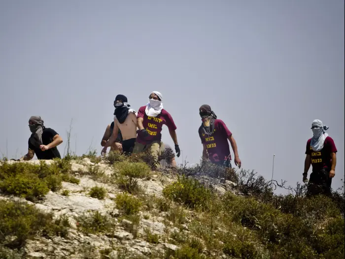 פעילי ימין רעולי פנים מתעמתים עם פלסטינים ליד יצהר, 2013 (AP) פעילי ימין רעולי פנים מתעמתים עם פלסטינים ליד יצהר, 2013 (AP)
