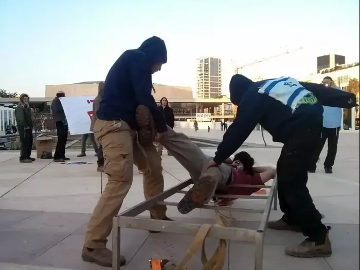 פעילי מטה "יהודי לא מענה יהודי" במיצג עינויים שעוברים הנערים העצורים בידי השב"כ, כיכר הבימה, תל אביב. דצמבר 2015 (אבי כהן) פעילי מטה "יהודי לא מענה יהודי" במיצג עינויים שעוברים הנערים העצורים בידי השב"כ, כיכר הבימה, תל אביב. דצמבר 2015 (אבי כהן)