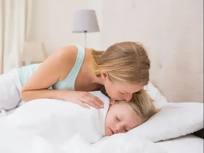 אמא משכיבה ילדה לישון (ShutterStock)