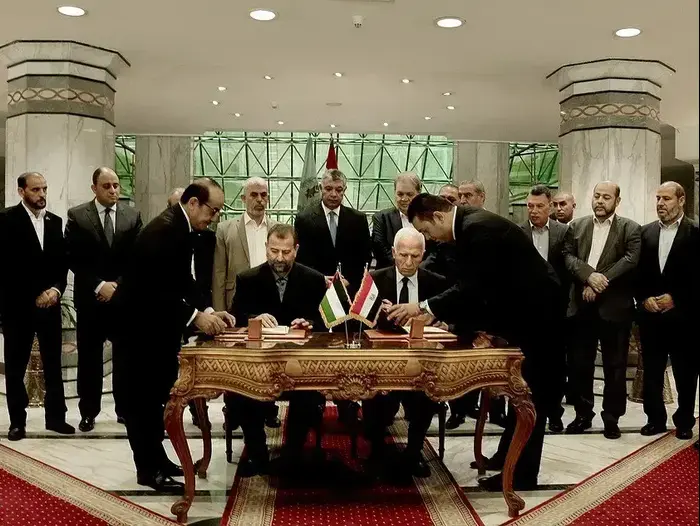 אל עארורי ועזאם אל אחמד בזמן החתימה על הפיוס 12 באוקטובר 2017 (מערכת וואלה! NEWS , עמוד הטוויטר של מרכז המידע הפלסטיני)