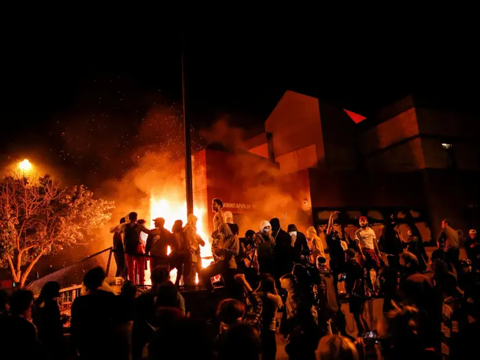 מפגינים מחוץ לתחנת המשטרה שנפרצה והוצתה במחאה על מותו של ג'ורג' פלויד. מיניאפוליס, מינסוטה, ארצות הברית. 29 במאי 2020 (רויטרס) מפגינים מחוץ לתחנת המשטרה שנפרצה והוצתה במחאה על מותו של ג'ורג' פלויד. מיניאפוליס, מינסוטה, ארצות הברית. 29 במאי 2020 (רויטרס)