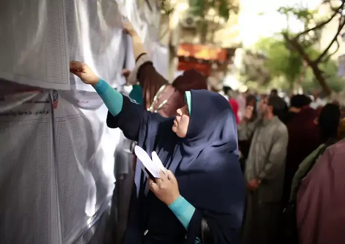 אישה מחפשת את שמה ברשימות מחוץ לקלפי בקהיר בבחירות לנשיאות מצרים שנפתחו היום. (רויטרס) אישה מחפשת את שמה ברשימות מחוץ לקלפי בקהיר בבחירות לנשיאות מצרים שנפתחו היום. (רויטרס)