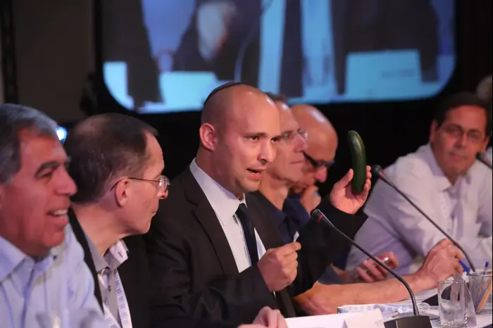 שר הכלכלה נפתלי בנת שולף מלפפון בנאומו בפורום קיסריה. נובמבר 2013 (יח"צ , יוסי זמיר) שר הכלכלה נפתלי בנת שולף מלפפון בנאומו בפורום קיסריה. נובמבר 2013 (יח"צ , יוסי זמיר)