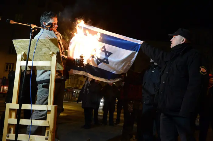 חבר הפרלמנט העצמאי בלאז לנהארט, לשעבר חבר בסיעת "יוביק", מצית את דגל ישראל מול משרד החוץ בבירה בודפשט. הונגריה, דצמבר 2014 (AP) חבר הפרלמנט העצמאי בלאז לנהארט, לשעבר חבר בסיעת "יוביק", מצית את דגל ישראל מול משרד החוץ בבירה בודפשט. הונגריה, דצמבר 2014 (AP)