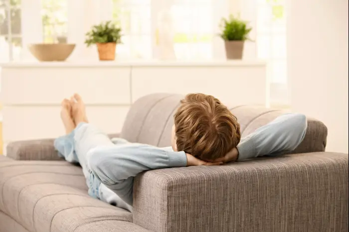 גבר על ספה בסלון (ShutterStock) גבר על ספה בסלון (ShutterStock)