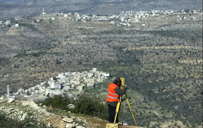 מודד באתר שבו תיבנה העיר הפלסטינית רוואבי, 2010 (AP) מודד באתר שבו תיבנה העיר הפלסטינית רוואבי, 2010 (AP)