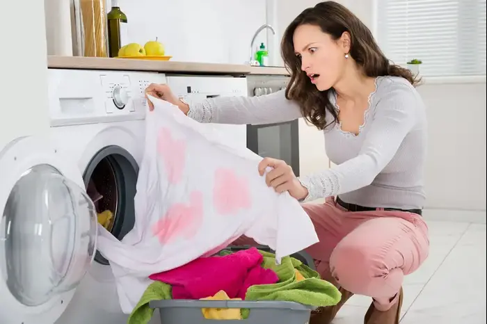 אישה מביטה על חולצה מוכתמת (ShutterStock)