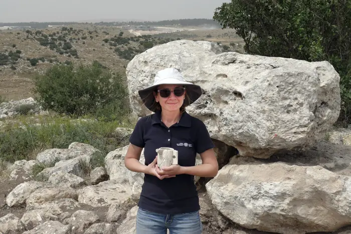 ארכיאולוגית מחזיקה ספל אבן מימי הבית השני שהתגלה בבית האחוזה מודיעין (מערכת וואלה! NEWS , אברהם טנדלר)