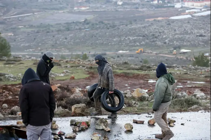 צעירים מחזקים את החסימות בכביש הגישה למאחז עמונה בבוקר הפינוי המיועד, 1 בפברואר 2017 (נועם מושקוביץ) צעירים מחזקים את החסימות בכביש הגישה למאחז עמונה בבוקר הפינוי המיועד, 1 בפברואר 2017 (נועם מושקוביץ)