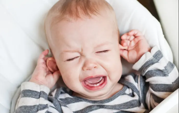 תינוק בוכה ומחזיק באוזניים (ShutterStock)