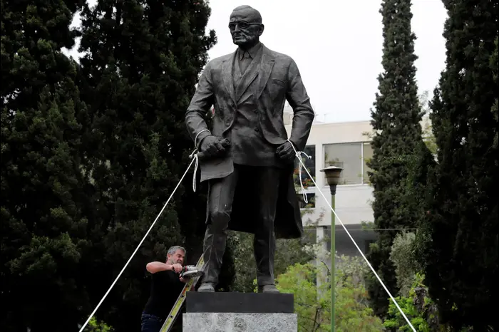 מפגין מנסה לנסר פסל של טרומן באתונה, יוון, במחאה על התקיפה האמריקנית בסוריה, 16 באפריל 2018 (רויטרס)