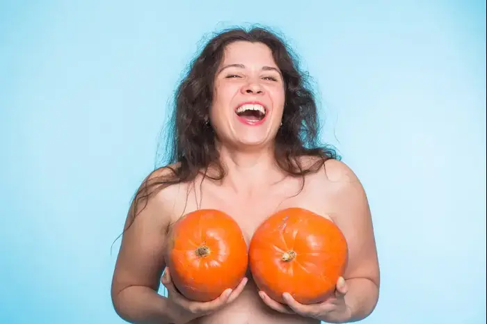 אישה מחזיקה דלעת מול החזה (ShutterStock)