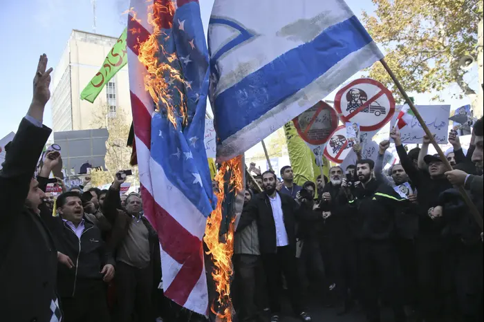 מפגינים שורפים דגלי ארה"ב וישראל בטהראן, איראן, לרגל יום השנה להשתלטות על השגרירות האמריקנית, 4 בנובמבר 2018 (AP) מפגינים שורפים דגלי ארה"ב וישראל בטהראן, איראן, לרגל יום השנה להשתלטות על השגרירות האמריקנית, 4 בנובמבר 2018 (AP)