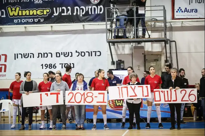 שחקניות ומאמנות א.ס. רמת השרון, אליצור נוה דוד רמלה מניפות שלט מחאה נגד אלימות כלפי נשים, אורנה אוסטפלד (אתר רשמי , עודד קרני, באדיבות מנהלת ליגת העל לנשים בכדורסל) שחקניות ומאמנות א.ס. רמת השרון, אליצור נוה דוד רמלה מניפות שלט מחאה נגד אלימות כלפי נשים, אורנה אוסטפלד (אתר רשמי , עודד קרני, באדיבות מנהלת ליגת העל לנשים בכדורסל)
