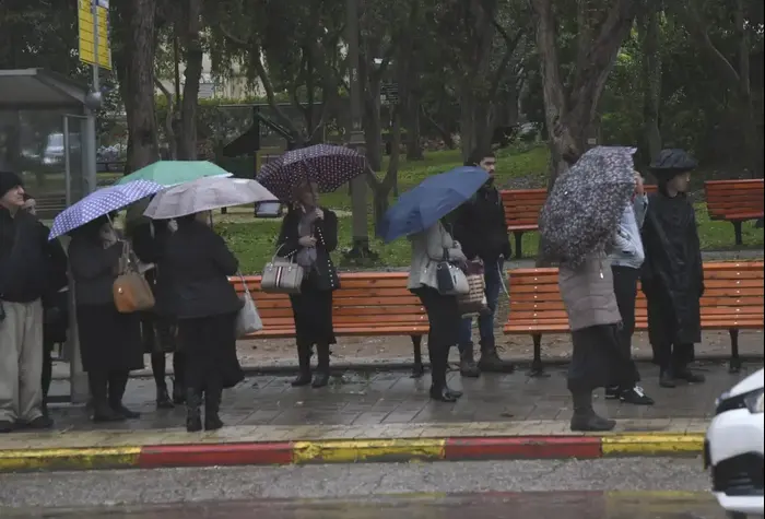 אנשים מתגוננים מפני הגשם בתל אביב 16 בינואר 2019 (ראובן קסטרו) אנשים מתגוננים מפני הגשם בתל אביב 16 בינואר 2019 (ראובן קסטרו)