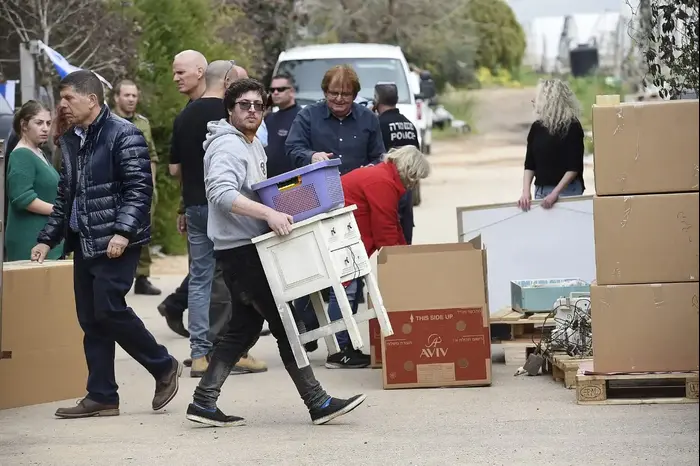 בני משפחת וולף מפנים את ביתם לאחר פגיעה ישירה של רקטה בקיבוץ משמרת, 25 במרץ 2019 (ראובן קסטרו)