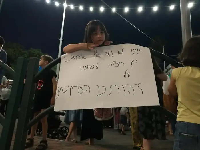 תושבת כפר כמא אוחזת שלט ובהפגנה נגד המרכז על הקרקע בו זכתה משפחה שלא מהעדה הצ'רקסית. 10 ביולי 2019 (אלי אשכנזי ) תושבת כפר כמא אוחזת שלט ובהפגנה נגד המרכז על הקרקע בו זכתה משפחה שלא מהעדה הצ'רקסית. 10 ביולי 2019 (אלי אשכנזי )
