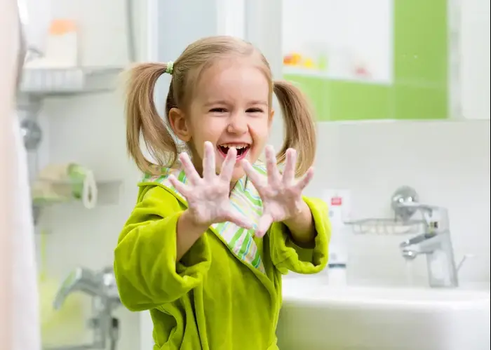 ילדה מראה את הידיים המסובנות שלה וצוחקת (ShutterStock) ילדה מראה את הידיים המסובנות שלה וצוחקת (ShutterStock)