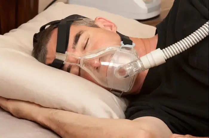 גבר ישן במיטה מחובר למכשיר CPAP להקלה על דום נשימה בשינה (ShutterStock) גבר ישן במיטה מחובר למכשיר CPAP להקלה על דום נשימה בשינה (ShutterStock)