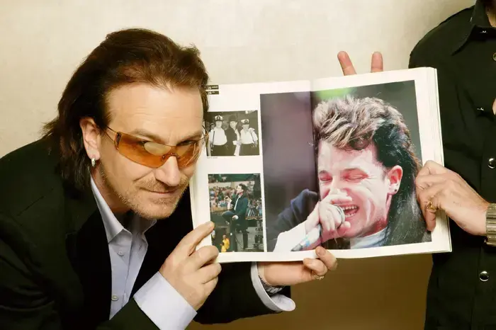 בונו עם תמונה של עצמו, 2005 (GettyImages , Dave Hogan) בונו עם תמונה של עצמו, 2005 (GettyImages , Dave Hogan)