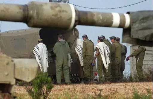 חיילי צה"ל מתפללים ליד טנק (AP , Eyal Warshavsky) חיילי צה"ל מתפללים ליד טנק (AP , Eyal Warshavsky)
