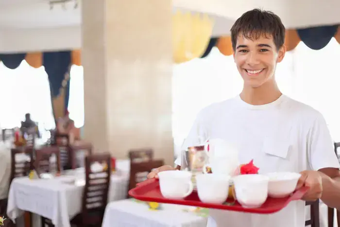 מלצר מחייך מגיש קפה (ShutterStock) מלצר מחייך מגיש קפה (ShutterStock)