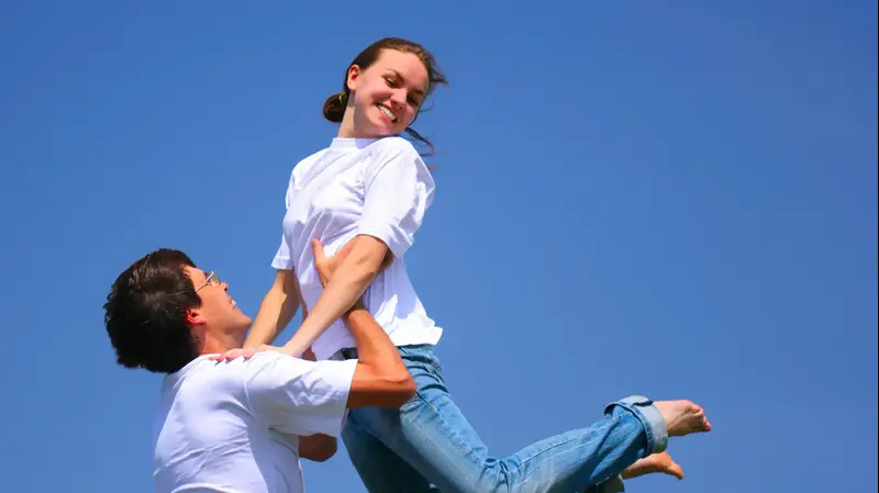 בני זוג שמחים לבושים בחולצה לבנה (ShutterStock)