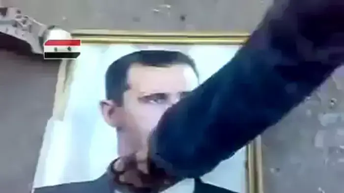 תיעוד: מפגינים רומסים את תמונתו של אסד