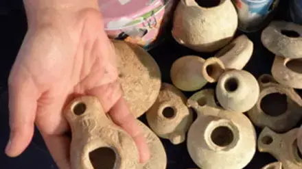 1.	נר רומי נדיר ועליו עיטור חרוטת מנורת שבעה קנים. ברקע - נרות חרס נוספים שנתפסו אצל חשוד בניסיון הברחה