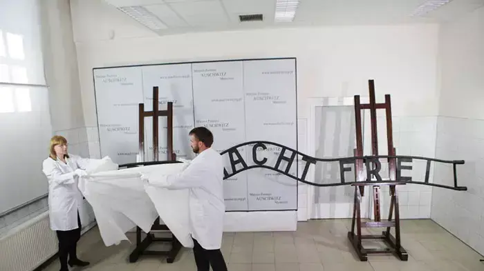 שלט "העבודה משחררת" המתוקן מוצג לתקשורת לפני הצבתו המחודשת בכניסה למחנה אושוויץ, פולין, 18 במאי 2011