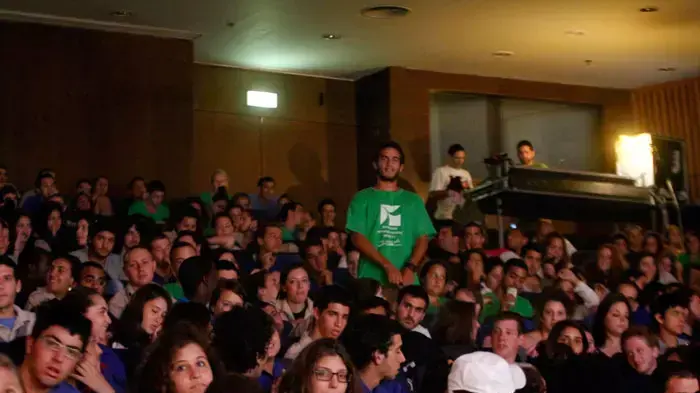 מתפרעי גלעד שליט מוחים בזמן ששר הביטחון אהוד ברק מברך בכנס הוקרה למתנדבי שנת שירות, יוני 2011 מתפרעי גלעד שליט מוחים בזמן ששר הביטחון אהוד ברק מברך בכנס הוקרה למתנדבי שנת שירות, יוני 2011