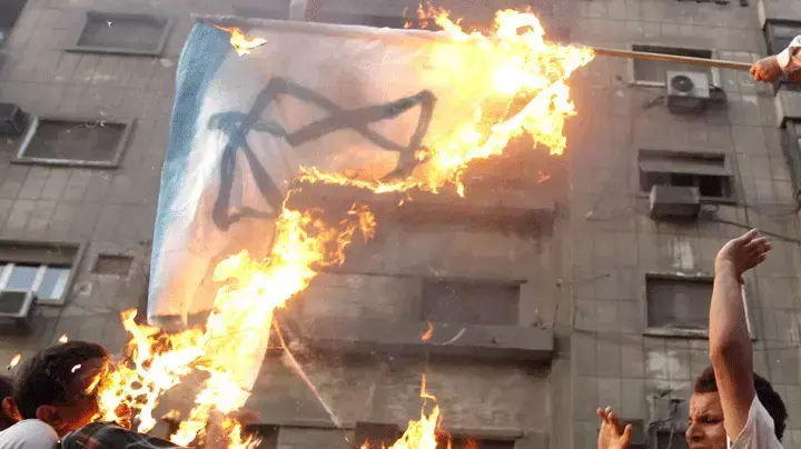 מפגינים שורפים את דגל ישראל מחוץ לשגרירות קהיר