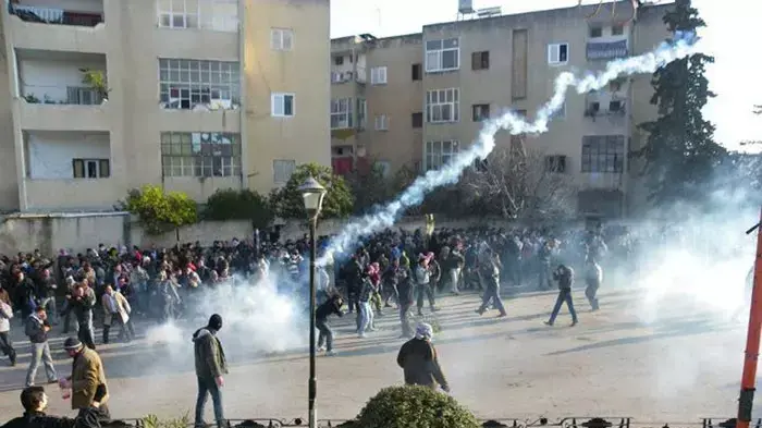 מפגינים נמלטים מירי גז מדמיע בהפגנה נגד שלטון אסד בעיר אידליב, סוריה, 30 בדצמבר 2011