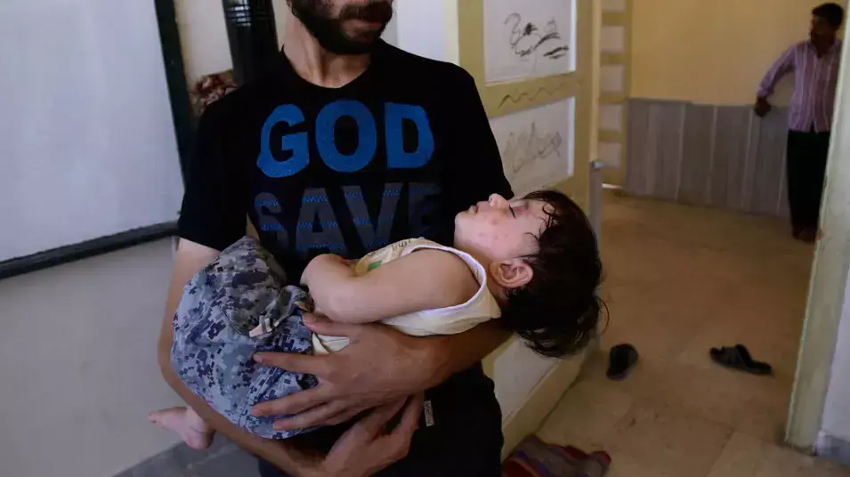 אב סורי ובנו הפצוע. חלב, ספטמבר 2012